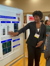 Najah Johnson explains her research poster to Dean Mark Gladwin